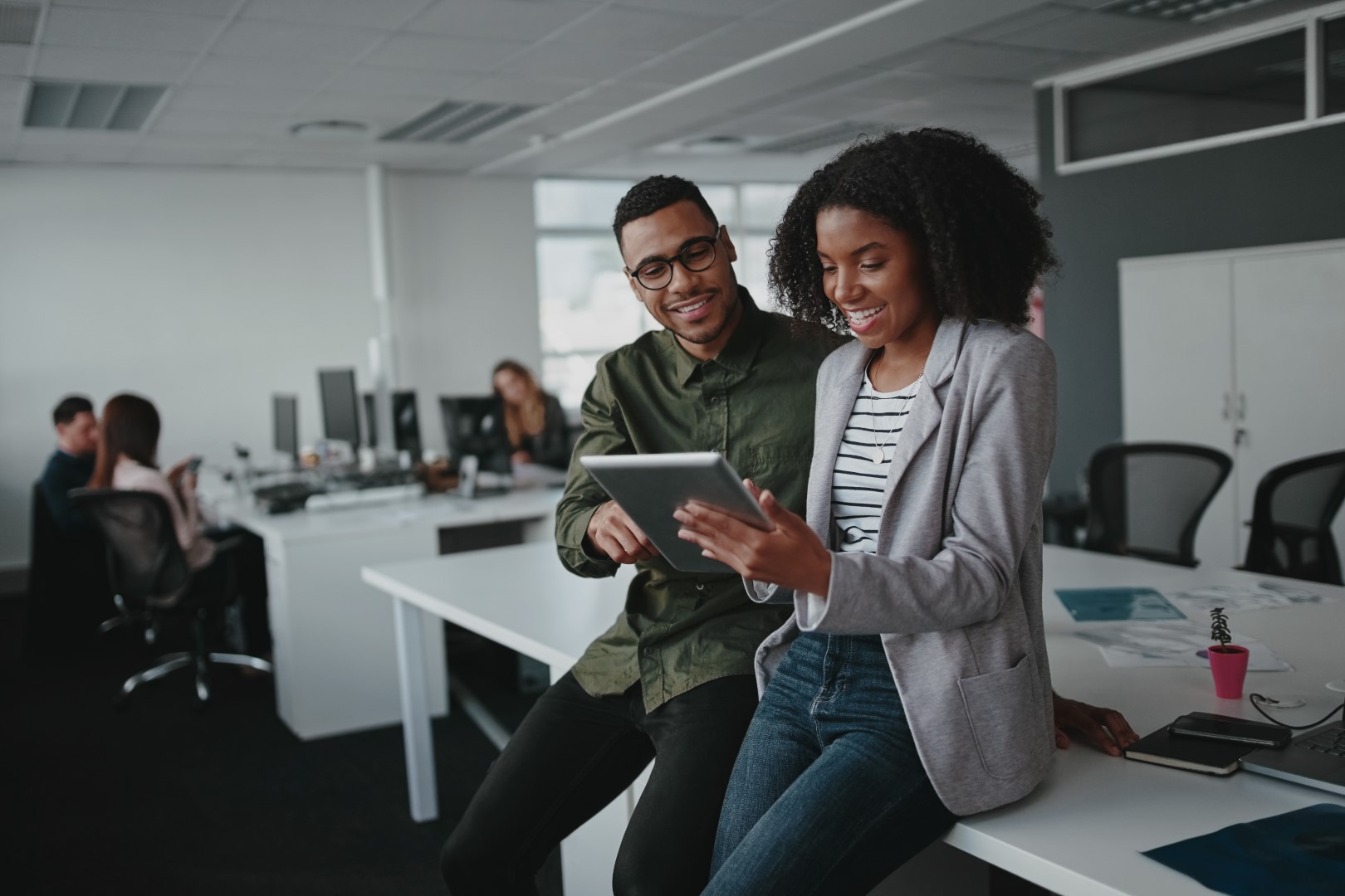 African American male and female looking at a tablet computer in an office environment
